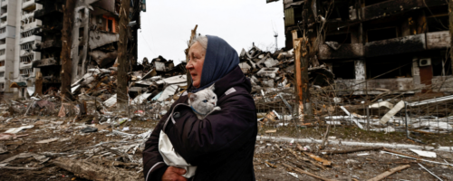Kobieta z kotem wśród zniszczeń spowodowanych rosyjskim atakiem rakietowym, Borodianka, Ukraina, 5 kwietnia 2022 r. fot. Zeohra Bensemra / Reuters / Forum