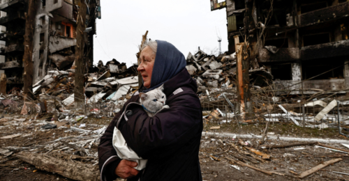 Kobieta z kotem wśród zniszczeń spowodowanych rosyjskim atakiem rakietowym, Borodianka, Ukraina, 5 kwietnia 2022 r. fot. Zeohra Bensemra / Reuters / Forum