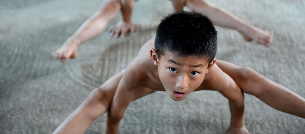 Chińscy chłopcy podczas ćwiczeń w centrum gimnastycznym w mieście Bozhou w prowincji Anhui fot. Liu Tianfu / Imaginechina / East News