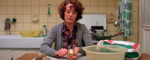 Kobieta obiera ziemniak. Kadr z filmu Jeanne Dielman