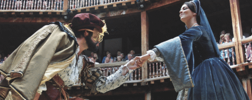 Scena teatralna. Mężczyzna w stroju z epoki kłania się kobiecie w niebieskiej sukni